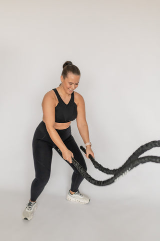 Photo of an athlete doing battle ropes in the Elansu Nova sports bra for fuller busts