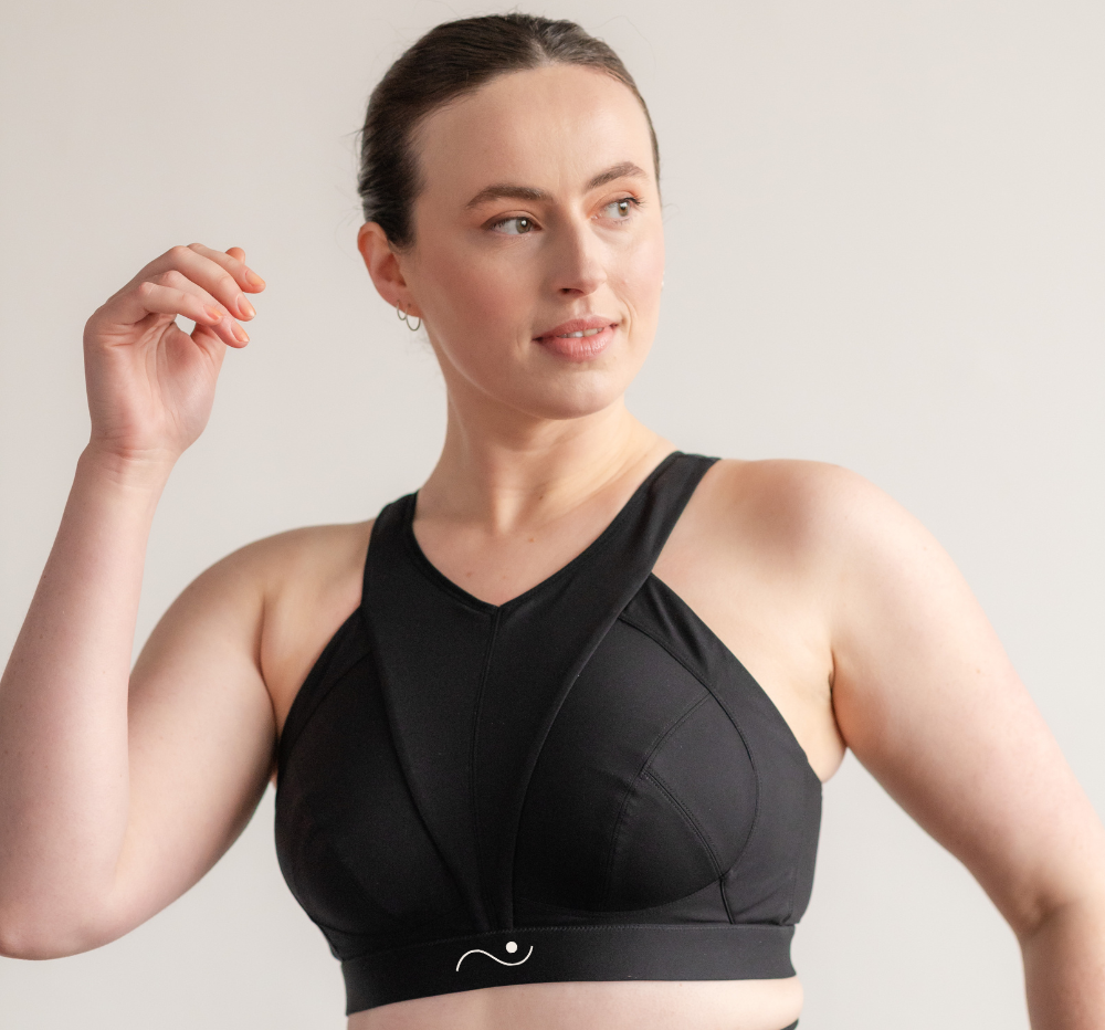 A woman modeling the Elansu sports bra for fuller bust women with a wide underband and a unique V panel for expert cup support