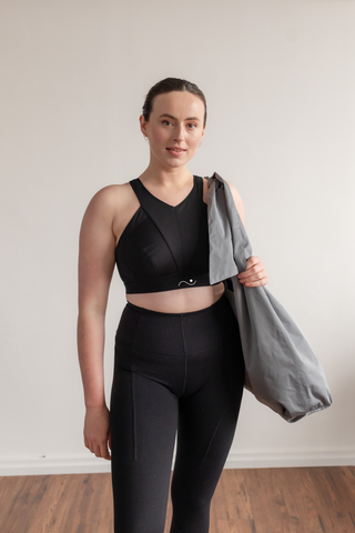 Photo of a woman with a fuller bust wearing the Nova sports bra by Elansu after a workout